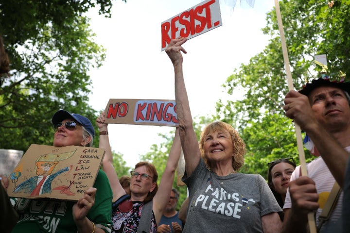 Demonstrators hold placards during a "No Kings" protest that underscore America's deep divisions over Trump's second term, at the Place de la Bastille in Paris on June 14, 2025.