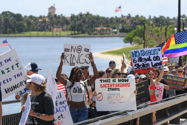 Protesters stand near President Donald Trump's Mar-a-Lago home (in background) during a "No Kings Day" protest on June 14, 2025 in West Palm Beach, Florida.