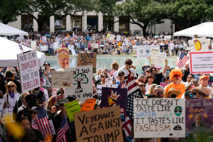 Os manifestantes se reúnem em bandeiras de Houston e segurando sinais, incluindo uma leitura, 