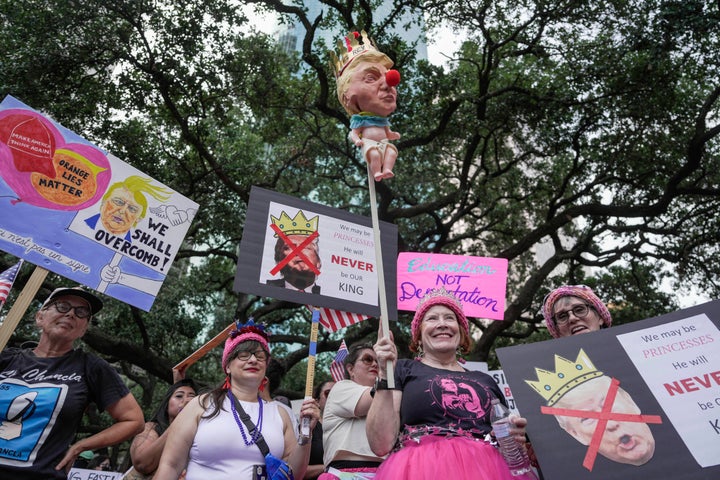 As pessoas se reúnem em Houston, incluindo um manifestante segurando uma escultura de Trump usando um nariz de palhaço vermelho.