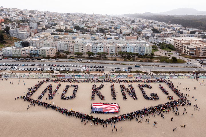As pessoas formam uma bandeira humana em Ocean Beach que lê 