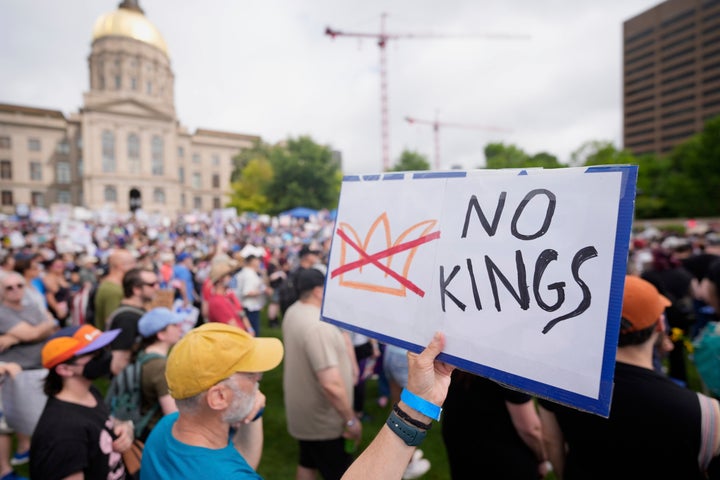 A demonstrator holds a sign during a "No Kings" protest Saturday in Atlanta.