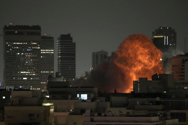 An explosion is seen during a missile attack in Tel Aviv, Israel, Sunday, June 15, 2025. (AP Photo/Leo Correa)