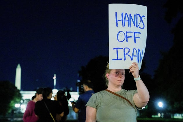 Διαδηλώτρια κρατάει μια πινακίδα καθώς ο πρόεδρος των ΗΠΑ Ντόναλντ Τραμπ (δεν απεικονίζεται) απευθύνει διάγγελμα προς το έθνος έξω από τον Λευκό Οίκο στην Ουάσιγκτον, ΗΠΑ, το Σάββατο 21 Ιουνίου 2025. Ο Τραμπ δήλωσε ότι ο αμερικανικός στρατός έπληξε τρεις τοποθεσίες στο Ιράν το Σάββατο, σηματοδοτώντας την πρώτη αμερικανική εμπλοκή σε άμεσες επιθέσεις κατά ιρανικών πυρηνικών περιουσιακών στοιχείων στη σύγκρουσή του με το Ισραήλ. Photographer: Aaron Schwartz/Bloomberg via Getty Images