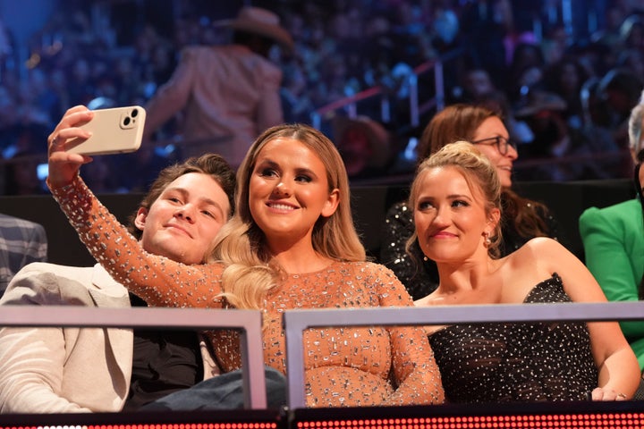 Montana Jordan, left with his now wife Jenna Weeks, Middle, and the television wife Emily Osment in a music awards program in 2024.