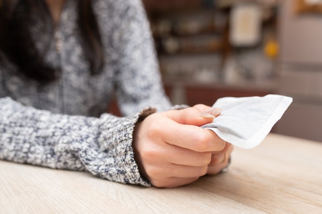 Woman's hand holding a disposable hand warmer