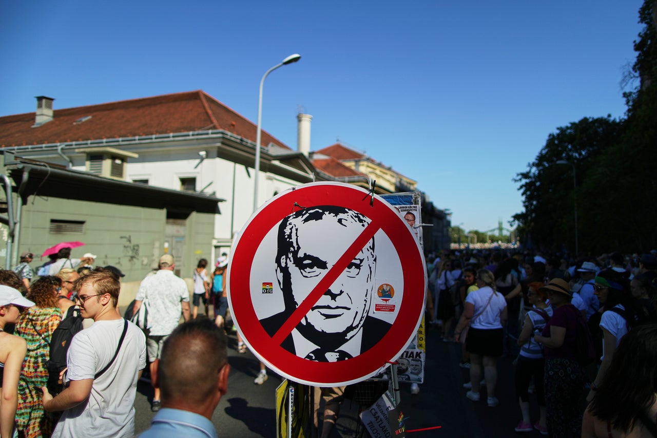 Συμμετέχοντες στην πορεία υπερηφάνειας περπατούν δίπλα από μια απεικόνιση του Ούγγρου πρωθυπουργού Βίκτορ Όρμπαν στη Βουδαπέστη της Ουγγαρίας, Σάββατο 28 Ιουνίου 2025. (AP Photo/Rudolf Karancsi)
