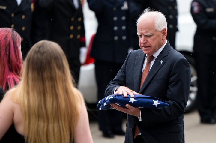 O governador de Minnesota, Tim Walz, apresenta uma bandeira americana para a família da deputada DFL Melissa Hortman e seu marido Mark Hortman após uma cerimônia fúnebre na Basílica de Saint Mary em 28 de junho de 2025 em Minneapolis, Minnesota. (Foto de Stephen Maturan/Getty Images)
