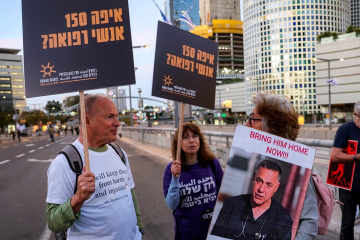 A demonstrator holds a sign depicting Dr. Hussam Abu Safiya while protesting Israel's killing of Gaza's aid workers outside the Israeli Defense Ministry headquarters in Tel Aviv on April 5, 2025. 
