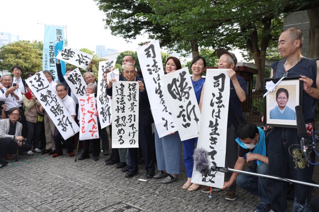 生活保護訴訟／「勝訴」などと書かれた紙を掲げる原告団ら