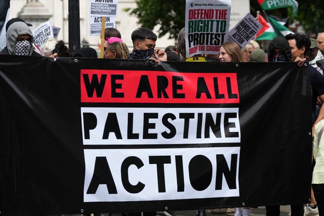 Demonstrators hold up a banner during a protest by Palestine Action group in London, Monday, June 23, 2025.