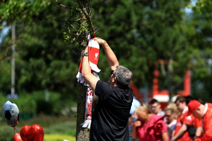 ΛΙΒΕΡΠΟΛ, ΑΓΓΛΙΑ - 03 ΙΟΥΛΙΟΥ: Ένας οπαδός της Λίβερπουλ δένει ένα κασκόλ της Λίβερπουλ σε ένα δέντρο στον Κήπο Μνήμης στο Στάδιο Άνφιλντ, καθώς αποδίδονται τιμές για τον Ντιόγκο Zότα στο Άνφιλντ στις 03 Ιουλίου 2025 στο Λίβερπουλ της Αγγλίας. Ο νυν παίκτης της Λίβερπουλ και διεθνής Πορτογάλος Jota έχασε τη ζωή του σε αυτοκινητιστικό δυστύχημα στη Zamora της Ισπανίας σε ηλικία 28 ετών (Photo by Jess Hornby/Getty Images).