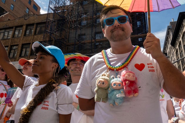 A man wears three Labubu plush toys in the NYC Pride March