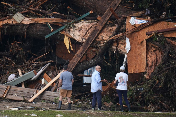 As pessoas olham para os detritos nas margens do rio Guadalupe, depois que uma inundação repentina varreu a área no sábado, 5 de julho de 2025, em Hunt, Texas. (AP Photo/Julio Cortez)