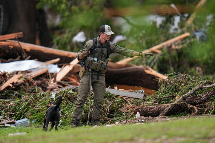 Officials comb through the banks of the Guadalupe River after a flash flood swept through the area Saturday, July 5, 2025, in Hunt, Texas. (AP Photo/Julio Cortez)