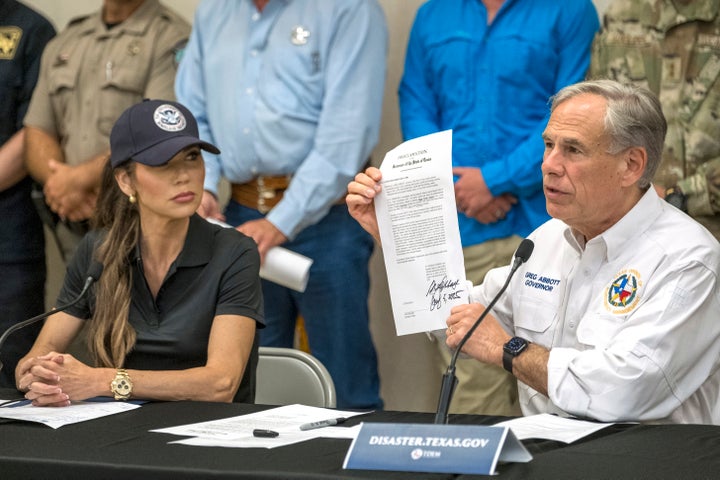 O governador do Texas, Greg Abbott, assina e mantém uma proclamação de declaração de desastres como a secretária de Segurança Interna Kristi Noem, à esquerda, olha durante uma conferência de imprensa sobre inundações recentes ao longo do rio Guadalupe, sábado, 5 de julho de 2025, em Kerrville, Texas. (AP Photo/Rodolfo Gonzalez)