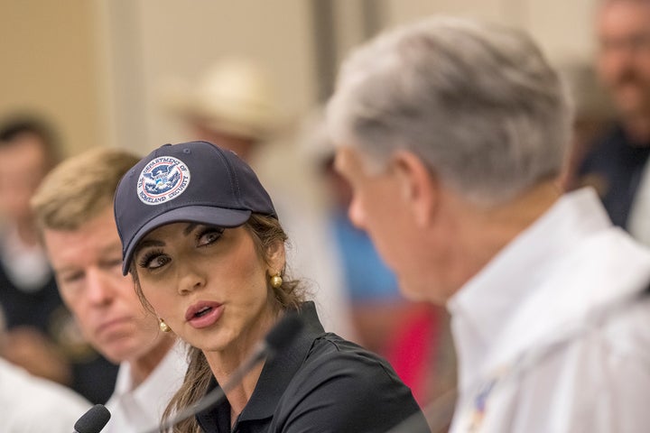 Homeland Security Secretary Kristi Noem, center, speaks with Texas Gov. Greg Abbott, right, about ongoing search and rescue efforts after recent flooding along the Guadalupe River during a press conference on Saturday, July 5, 2025, in Kerrville, Texas. (AP Photo/Rodolfo Gonzalez)