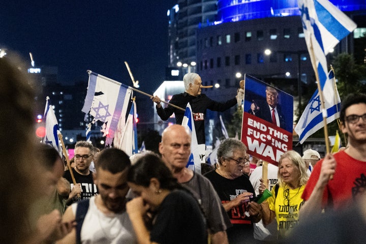 A demonstrator wearing a mask depicting Israeli Prime Minister Benjamin Netanyahu with an elongated nose, evoking the literary character Pinocchio, gestures during a protest demanding a ceasefire in Gaza and the release of Israeli captives, in Tel Aviv, Israel, on July 5, 2025. 