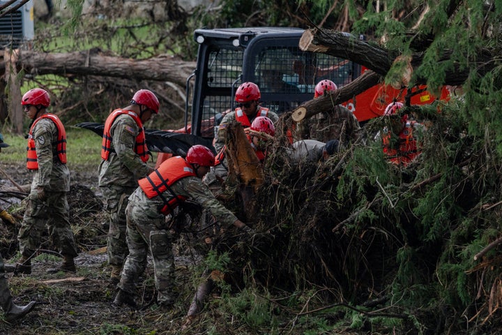 Search and recovery workers dig by rubble looking for survivors around Camp Mystic.
