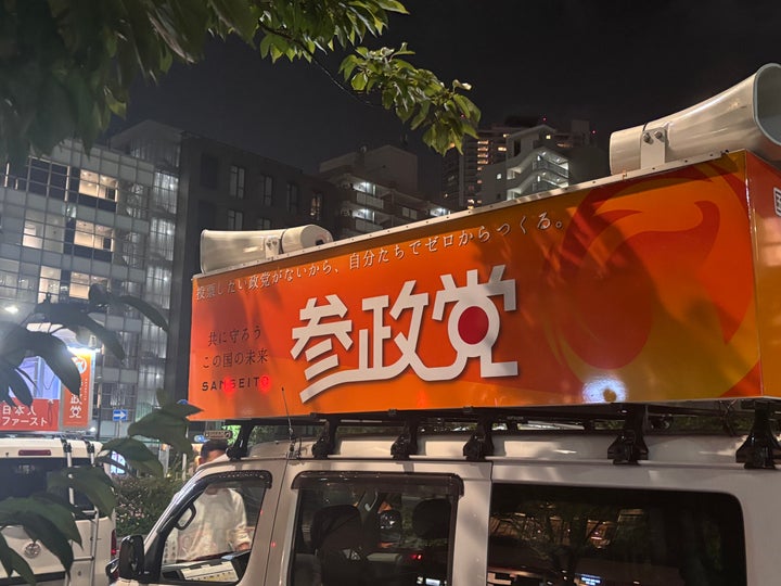 街頭演説での、参政党の選挙カー。看板には「投票したい政党がないから、自分たちでゼロからつくる」「日本人ファースト」の文字も
