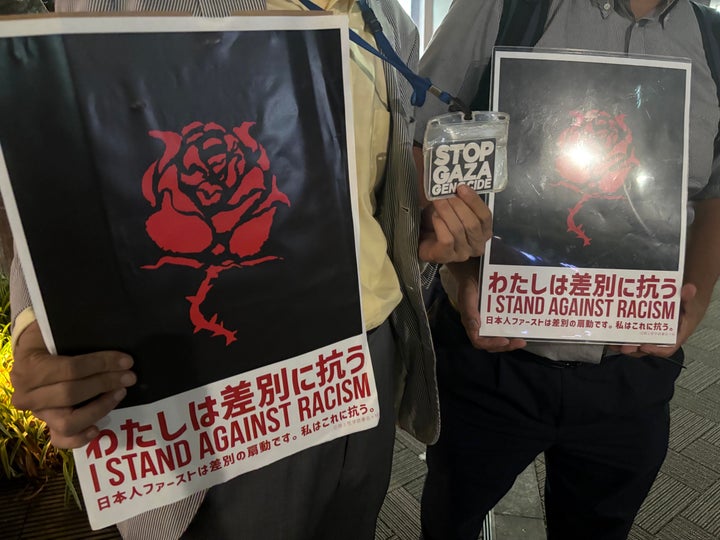 「わたしは差別に抗う。日本人ファーストは差別の煽動です」とのプラカードを掲げる男性2人