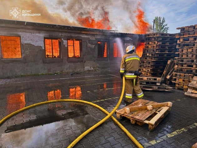 Πυροβέστης σβήνει φωτιά μετά από ρωσική επίθεση στο Κίεβο (Ukrainian Emergency Service via AP)