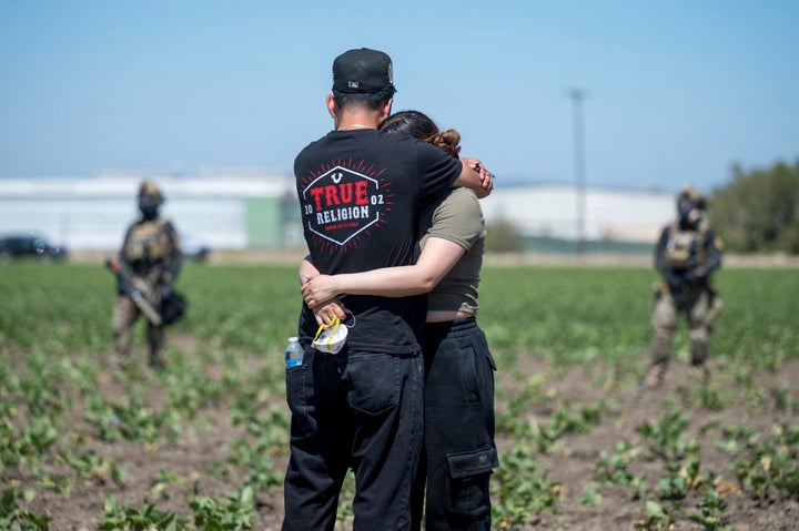 Arturo Rangel hugs Judith Ramos, whose father works at the greenhouse in the background as federal immigration agents block access during a raid in the agriculture area of Camarillo, California, Thursday, July 10, 2025.