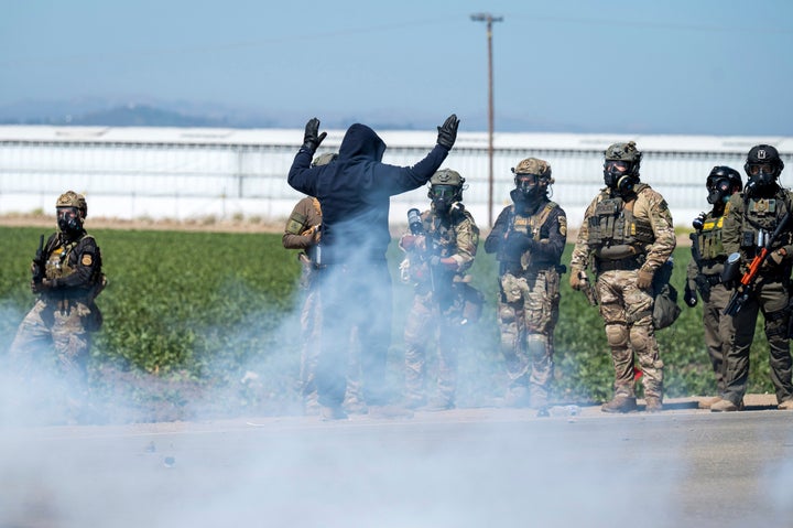 Federal immigration agents toss tear gas at protesters during a raid in the agriculture area of Camarillo, California, Thursday, July 10, 2025.