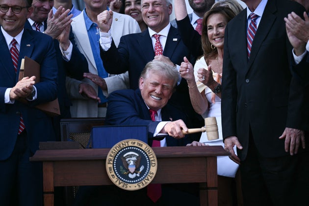 U.S. President Donald Trump (C) bangs a gavel after signing the 