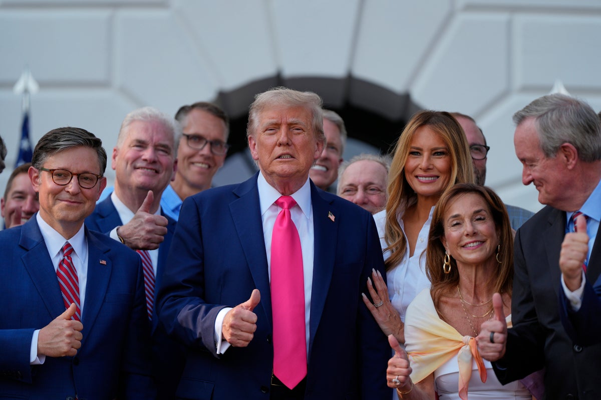 President Donald Trump poses for a photo after signing his signature bill of tax breaks and spending cuts at the White House, Friday, July 4, 2025, in Washington, surrounded by members of Congress, including House Speaker Mike Johnson of La., left. (AP Photo/Julia Demaree Nikhinson)