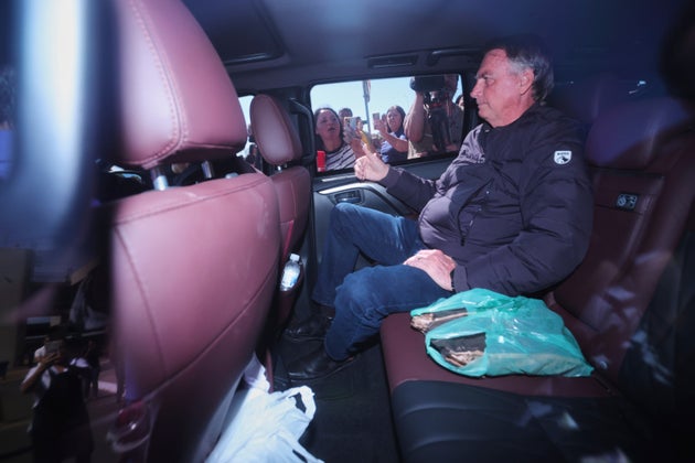 Ο πρώην πρόεδρος της Βραζιλίας Ζαΐρ Μπολσονάρου φεύγει από τη Γραμματεία Σωφρονιστικής Διοίκησης όπου έφτασε μετά τη διαταγή του Ανώτατου Δικαστηρίου να του τοποθετηθεί ηλεκτρονικός πομπός στον αστράγαλο στη Μπραζίλια της Βραζιλίας, Παρασκευή 18 Ιουλίου 2025. (AP Photo/Luis Nova)