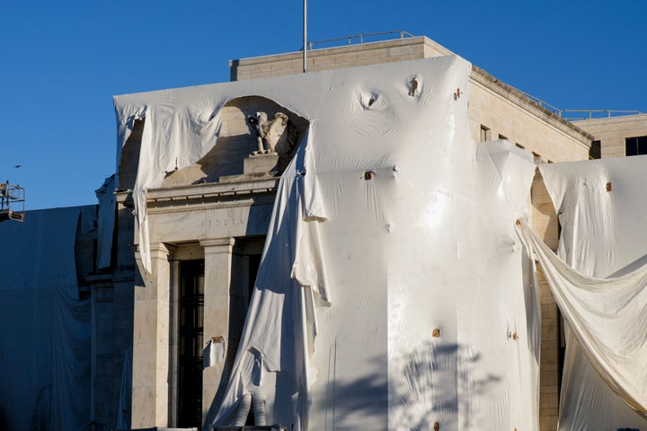 The sculpture of an eagle looks from behind the construction of protection on the facade when the building of the Federal Reserve Board is subjected to interior and exterior renovations, in Washington, on Monday, October 23, 2023. (AP Photo/J. Scott Applewhite, Archive)