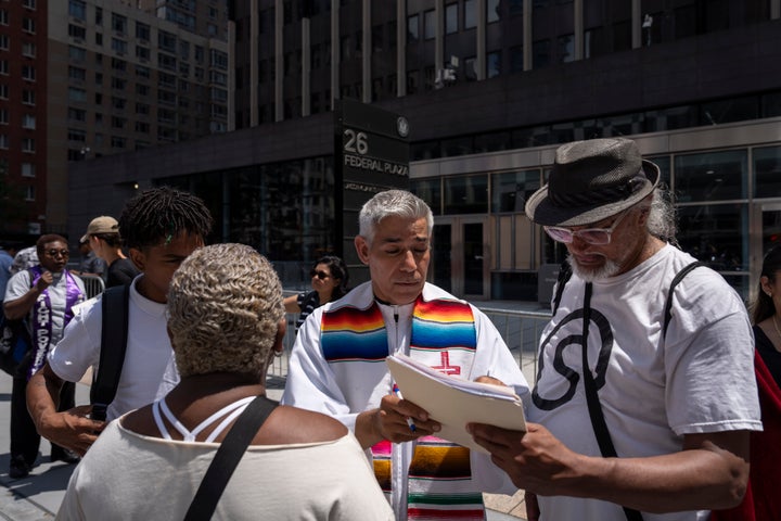 The Rev. Fabián Arias, a volunteer court observer, assists an immigrant family outside the Jacob K. Javits federal building in New York City, on July 17, 2025.