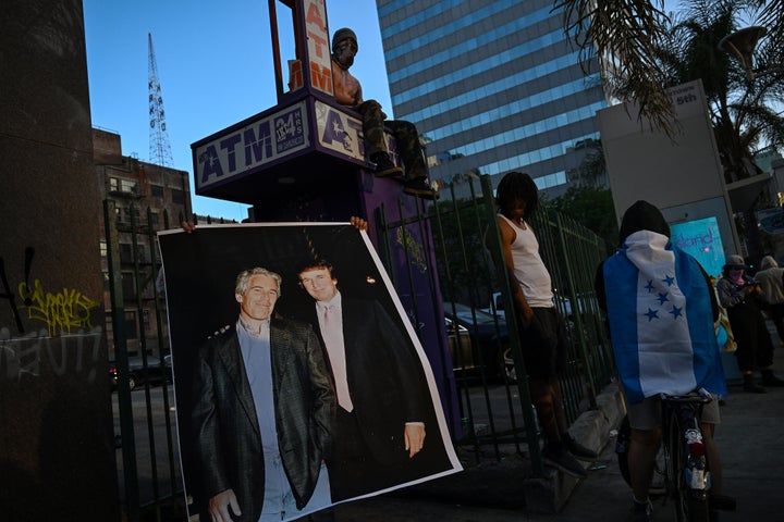 Un manifestante tiene una foto del delincuente sexual condenado Jeffrey Epstein y Donald Trump en Los Ángeles.