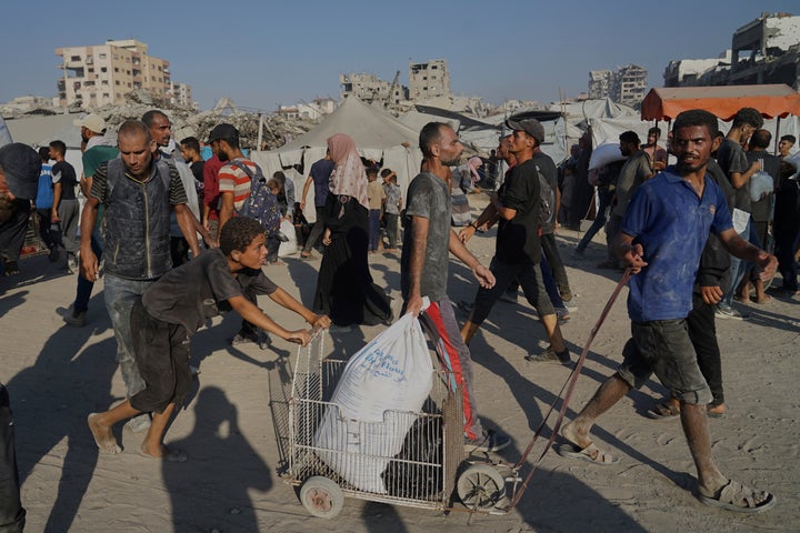 Israel Begins Every day Pause In Preventing In 3 Gaza Areas To Enable 'Minimal' Help As Starvation Grows 3 Palestinians carry sacks of flour unloaded from a humanitarian aid convoy that reached Gaza City from the northern Gaza Strip, Saturday, July 26, 2025. (AP Photo/Jehad Alshrafi)