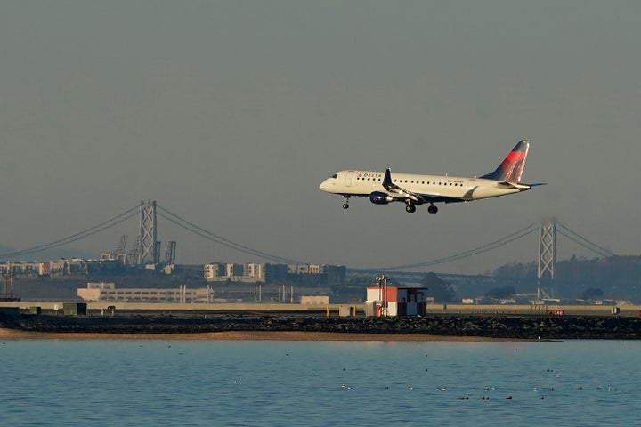 The pilot was taken into custody Saturday on charges of child sexual abuse, according to a Homeland Security spokesperson. A Delta Air Lines flight lands at San Francisco International Airport.