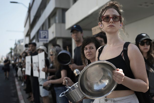 イスラエル・テルアビブの在イスラエル米国大使館支局前で、、ガザの飢餓に抗議して鍋やフライパンを打ち鳴らすデモをするイスラエルの活動家たち（2025年7月24日）