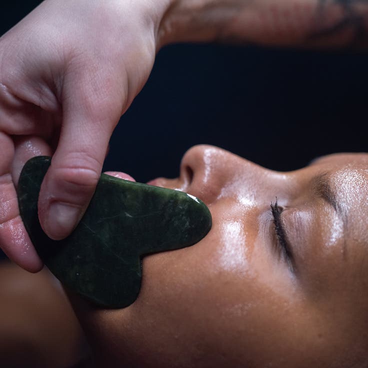 Close-up of young and beautiful woman during Chinese traditional massage with Gua Sha stain.