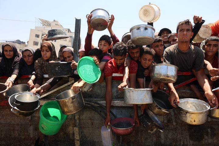 Palestinians receive lentil soup at a food distribution point in Gaza City on August 2, 2025. The World Health Organisation warned on July 27 that malnutrition was reaching "alarming levels" in Gaza. (Photo by Omar AL-QATTAA / AFP)