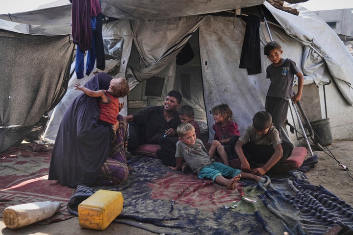 Abeer and Fadi Sobh gather in their tent with their children at a camp for displaced Palestinians in Gaza City, Thursday, July 24, 2025. (AP Photo/Jehad Alshrafi)