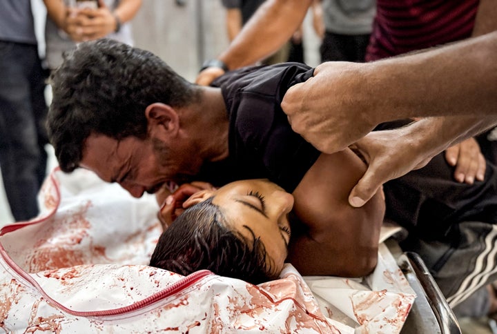 Loved ones mourn over the body of Reyyan al-Fuqaha at Nasser Hospital on Aug. 1, 2025. Israeli forces killed Reyyan and many other Palestinian aid-seekers others in an attack west of Rafah, Gaza.
