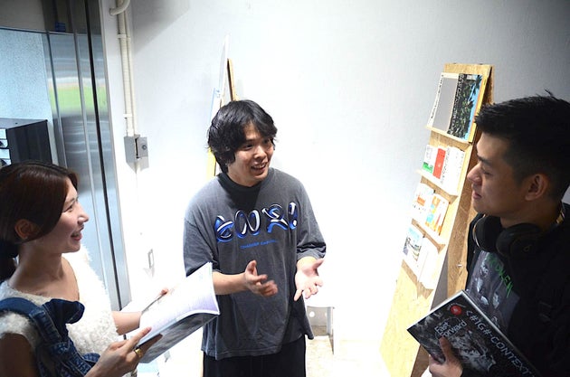 訪れたお客さんに雑誌の狙いを話す中路さん（中央）