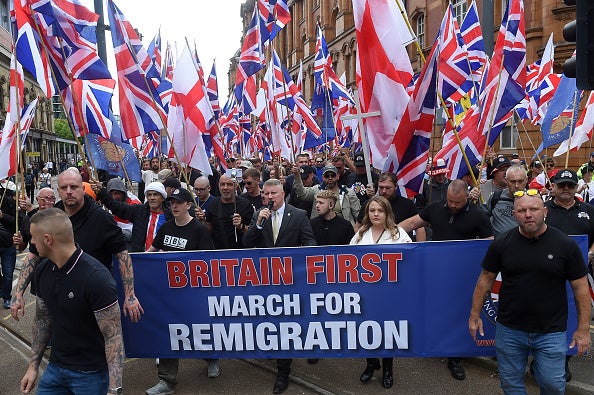 Far-right Britain First party co-leaders Paul Golding (front row CL) and Ashlea Simon (front row CR) lead supporters on an anti-immigration 'March for Remigration' calling for mass deportations, in Manchester, northwest England, on August 2, 2025.
