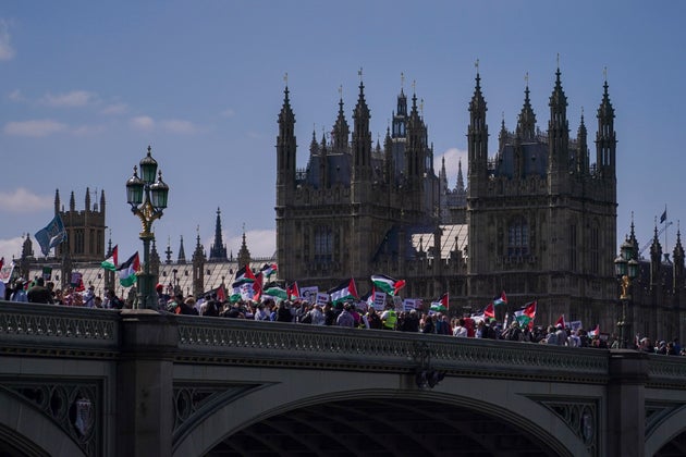Demonstrators hold flags as they cross Westminster Bridge during a demonstration in support of the Palestinian people in Gaza, in London, Saturday, May 17, 2025. 