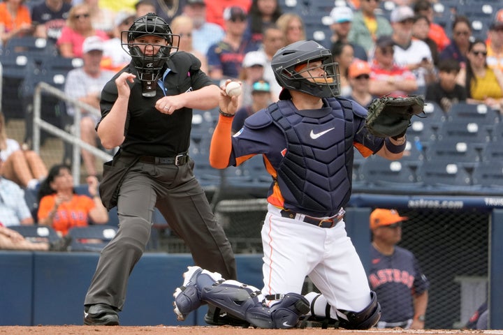 Home plate umpire Jen Pawol, left, calls a strike as Houston Astros catcher Victor Caratini throws back a pitch during the first inning of a spring training baseball game between the Astros and Miami Marlins Sunday, March 10, 2024, in West Palm Beach, Fla. (AP Photo/Jeff Roberson)
