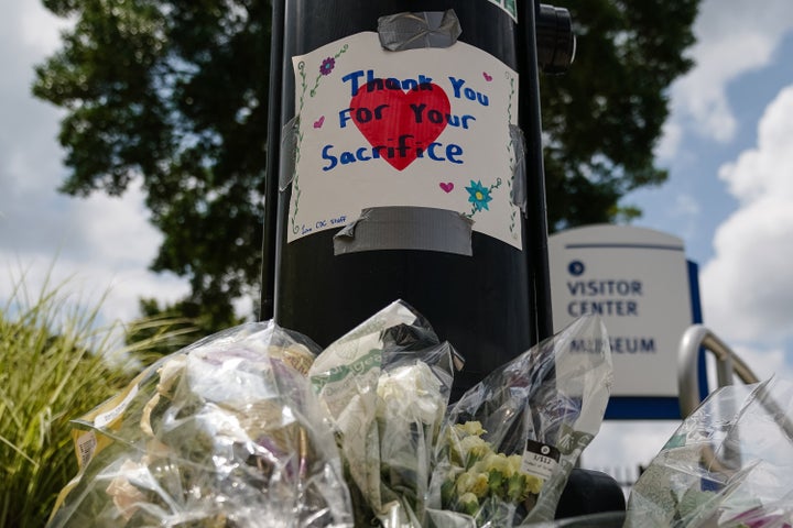 Flowers are placed below a handwritten sign outside the Centers For Disease Control and Prevention's (CDC) global headquarters in Atlanta on Aug. 9, 2025, one day after a Georgia man opened fire on the campus and killed a police officer.