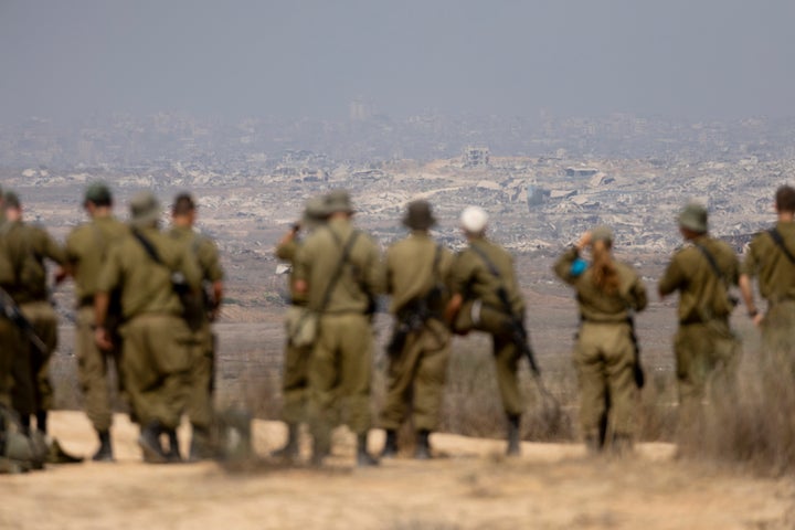 Israeli soldiers look over a destroyed northern Gaza from a viewpoint on the Israeli side of the border on Aug. 13, 2025.