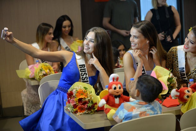 （左）ミス・ユニバース世界大会にロシア代表として出場したクセーニヤ・アレクサンドロワさん。他の出場者とともに自撮りする様子（2017年12月7日）