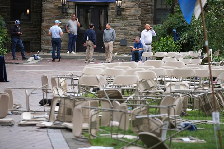 People use their phones in a mess of toppled chairs at the Villanova University campus where an active shooter was reported Thursday, Aug. 21, 2025, in Villanova, Pa.