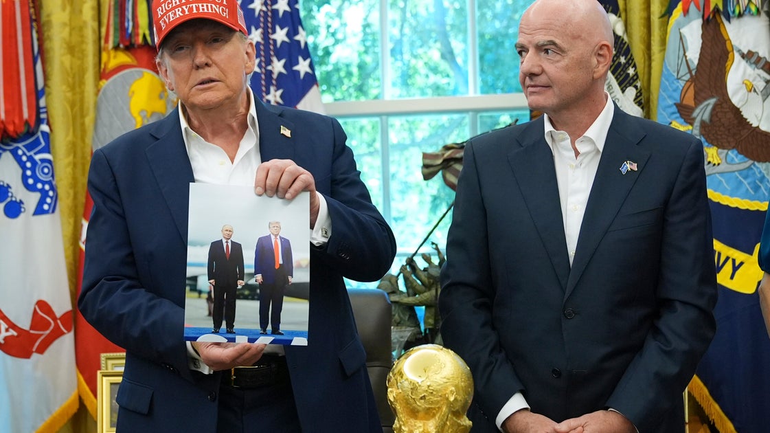 Trump Holds Aloft Photo Of Himself And Putin, Says Russian Leader May Attend World Cup